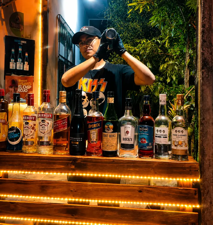 El bartender y asaditero de Tragos Kuy & Asaditos Tosta preparando tragos detrás de la barra